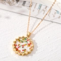 Gros plan du pendentif doré en forme de soleil avec de vraies fleurs séchées - Floral Coloré