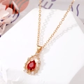 Elegante collana dorata con ciondolo in cristallo rosso a goccia e diamanti incastonati - Collana a goccia d'acqua vuota rossa