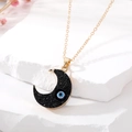 Boho-Halskette mit schwarzem Mondanhänger und blauem Auge auf weißem Stein präsentiert - Schwarzer Mond Stil