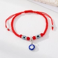 Close-up of handmade red string bracelet featuring blue evil eye charms and heart accents - Red Cord Large Round Eye