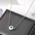 Minimalist silver chain necklace with a colorful resin Evil Eye pendant on black jewelry box - White Eye