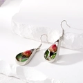 Detailed view of silver teardrop earrings with real red dried rose buds and green leaves - Red Earrings