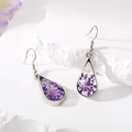 Detail view of teardrop earrings with purple dried flowers in resin on white stone - Purple Pearl Earrings