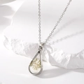 Detail of teardrop dried flower necklace with white petals on white stone prop - White Necklace