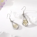 Detail of drop-shaped earrings featuring white dried flowers in silver metal frame - White Pearl Drop Earrings