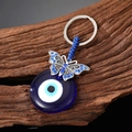 Tribale sleutelhanger met boze oog en vlinder van antiek zilver en blauwe glazen kraal - Vlinder Boze Oog Stijl
