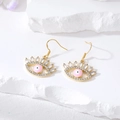 Detailaufnahme der goldenen Evil-Eye-Ohrringe mit pinker Emaille und weißen Zirkonia - Rosa Wimpernauge