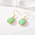 Detalle de pendientes de gota dorados con cristales verdes de pera y destellos irisados - Verde Deslumbrante Gota