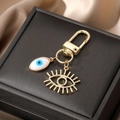 Golden Evil Eye keychain with white enamel heart and hollow eyelash pendant on silk - White Shell Evil Eye Ring
