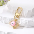 Detailed close-up of a pink enamel evil eye keychain with rhinestones on stone - Hollow Eyelash Eye / Pink