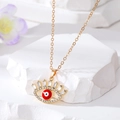 Détail du collier œil protecteur doré avec centre rouge et cils en zircons brillants - Œil à Cils Rouge