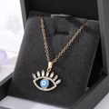 Collier vintage avec pendentif œil maléfique plaqué or et zircons dans une boîte à bijoux - Œil de Cils Bleu Clair