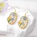 Dettaglio degli orecchini a forma di viso con veri fiori essiccati in resina dorata - Orecchini / Orecchini Oro Viso Fiore Blu Chiaro