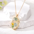 Collana con viso astratto con fiori secchi in resina e catena dorata - Collana / Collana Oro Viso Fiore Blu Chiaro