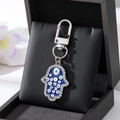 Hamsa-Hand-Schlüsselanhänger mit blauen bösen Augen und funkelnden Strasssteinen - Silberne Vieläugige Blaue Palme