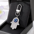 Dettaglio portachiavi mano di Fatima in argento con cristalli e occhio di bue blu - Portachiavi Argento Mano Grande / Argento