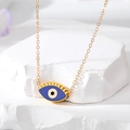 Détail macro du pendentif œil maléfique doré avec émail bleu et longs cils dorés - Style de Cils Bleu Foncé