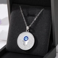 Silberne Hamsa-Hand und Evil Eye Anhängerkette auf einer dunklen Samtschmuckschatulle - Silberne Handfläche
