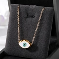 Collier oeil maléfique avec cils dorés et pendentif émail bleu sur présentoir - Cils Blancs