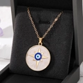 Detail of golden Evil Eye necklace with white shell inlay inside a premium jewelry box - Gold Meteor