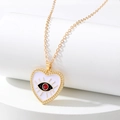 Detalle de colgante corazón ojo turco con esmalte blanco y cuentas doradas - Corazón Blanco Ojo Rojo