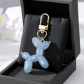 Macro shot of light blue iridescent balloon dog keychain on black velvet jewelry box - Large Laser Light Blue