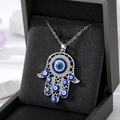 Detail of Hamsa Hand pendant with blue Evil Eye beads in a luxury black jewelry box - Silver Hollow Multi-Eyes