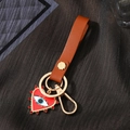 Detail of red heart pendant with evil eye motif and leather strap on gold keychain - Red Enamel Heart With Rhinestones (Brown Leather Strap)
