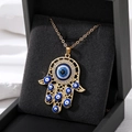 Vintage Hamsa Hand necklace with blue evil eye pendant on black velvet box - Gold Hollow Multi-Eyes