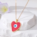 Makroaufnahme eines herzförmigen blauen Evil-Eye-Anhängers an einer Goldkette - Rotes Herz