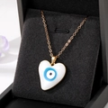 Elegant heart-shaped blue evil eye pendant necklace in golden finish on black jewelry box - White Heart