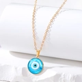Minimalist evil eye pendant necklace with golden chain on white mineral display stand - Small Round Eye / Blue