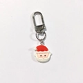 Dettaglio ravvicinato di un portachiavi di Babbo Natale in resina con chiusura a moschettone - Babbo Natale