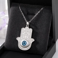 Vue détaillée du pendentif Main de Fatma avec œil bleu sur fond de velours noir - Œil Bleu Grande Main De Fatima Argentée