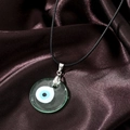 Detailed view of the Evil Eye glass pendant with silver clasp and black wax cord - Transparent Green