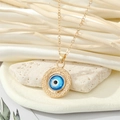 Gros plan du collier pendentif œil bleu doré sur pierre naturelle avec soie - Style Œil Bleu Rond