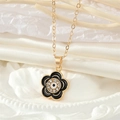 Detalle del collar con colgante de flor dorada con cristales y motivo de ojo turco - Negro