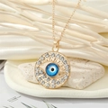 Vue macro du pendentif Main de Fatma en or avec cristaux bleus et halo scintillant - Petit Style Œil Rond Ajouré