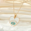 Détail du pendentif cœur œil protecteur en émail bleu sur une chaîne dorée - Œil de Cœur Blanc