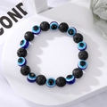 Bracelet fait main en perles de lave noire avec charmes œil bleu sur support blanc - Perles Noires Oeil Bleu