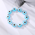 Turkish evil eye beaded bracelet with blue round charms and silver spacers on a magazine page - Silver Beads Blue Eye