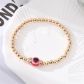 Handmade gold beaded bracelet featuring a red evil eye charm and sparkling accents - Red Evil Eye