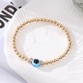 Detail of evil eye beaded bracelet with gold metal beads and sparkling rhinestone spacers - Light Blue Round Eye