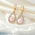 Detail van gouden traanvormige boze oog oorbellen met roze emaille en sprankelende steentjes - Roze oorbellen