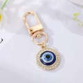 Detail of blue evil eye keychain with sparkling rhinestones and golden metal finish - Round Eye with Rhinestones