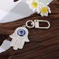 Macro detail of Hamsa Hand keychain with blue evil eye and sparkling rhinestones - Large Silver Hamsa Hand Eye