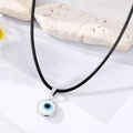 Zilveren evil eye ketting met blauwe glazen hanger aan een zwart leren koord - Wit