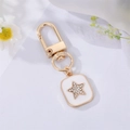 Detailed macro view of gold-plated star pendant with white enamel and sparkling rhinestones - White Enamel Star