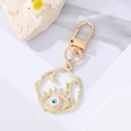 Detalle del llavero de ojo turco dorado con esmalte azul y amuleto de hoja - Ojo Rosa Esmaltado Irregular