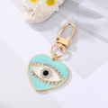 Detailed macro view of heart-shaped evil eye keychain with blue enamel and rhinestones - Lake Blue Heart White Crystal Eye